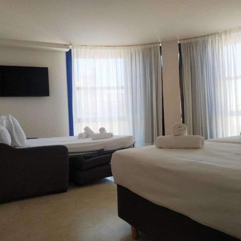 Room with twin beds and brown sofa